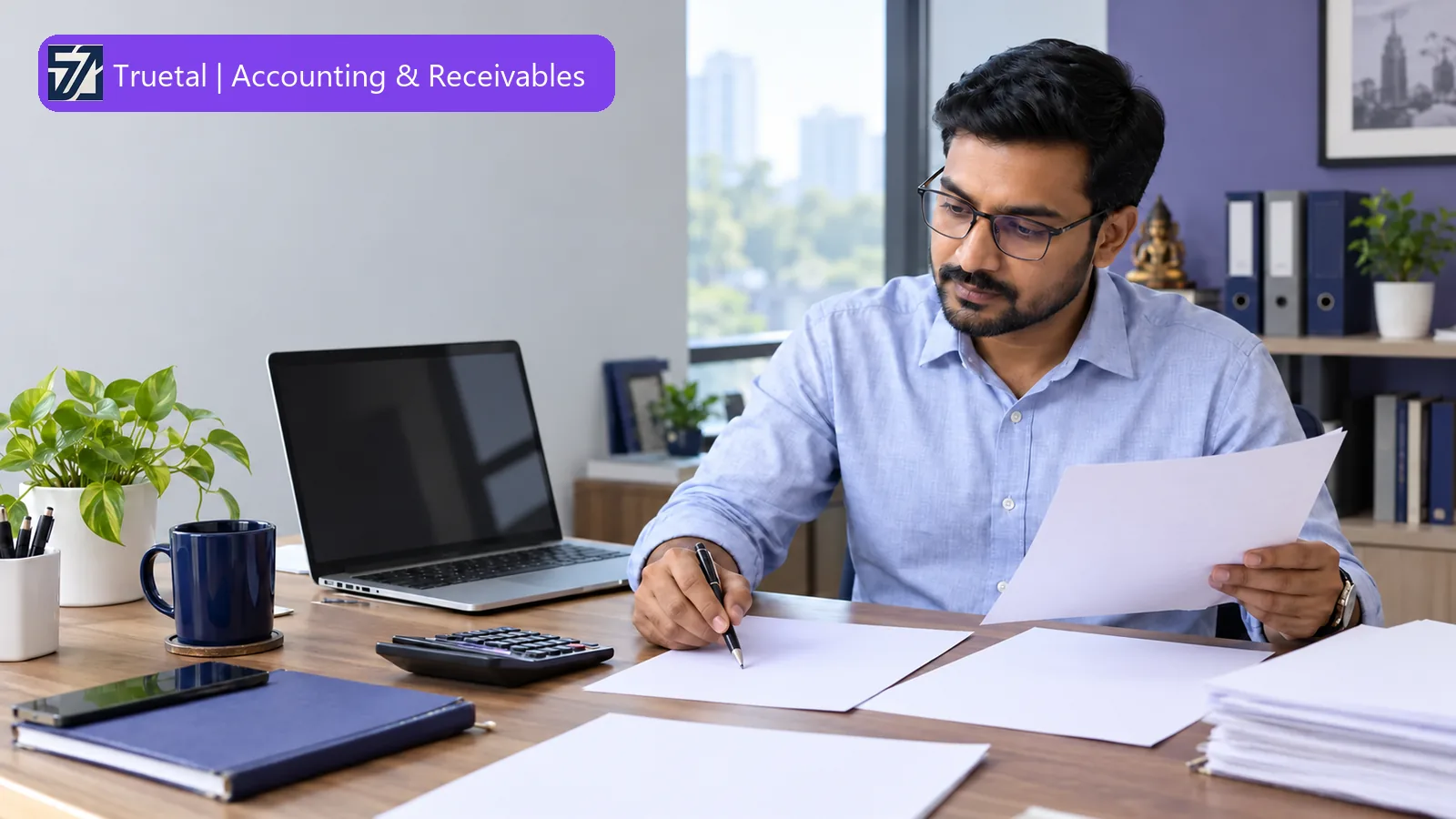 Indian finance professional reviewing bank-reconciliation working papers beside a calculator and an inactive laptop.